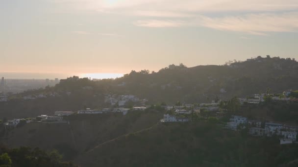 Panorama města z Beverly Hills. Kamera se pohybuje pomalu. Nádherná scenérie zelených stromů. Luxusní domy bohatých lidí. Krásná scenérie při západu slunce. — Stock video