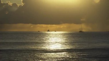 Tropikal günbatımının inanılmaz renkleri. Okyanus ufkunda yüzen yelkenli siluetleri. Oahu Adası, Hawaii Yaz Tatili.