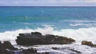 Pasifik Okyanusu 'nun Mavi Dalgaları Oahu Adası Volkanik Uçurumlarını Yener. Turkuaz sulu boya. Güneşli bir gün. Hawaii Takımadası. DCI 4k. Yavaş Hareket.
