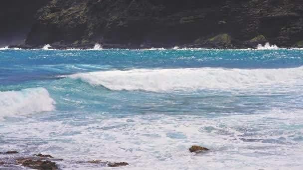 Blue Waves of the Pacific Ocean Beats Oahu Island Volcanic Cliffs. Turquoise water color. Clear sunny day. Archipelago Hawaii. DCI 4k. Slow Motion. — Stock Video