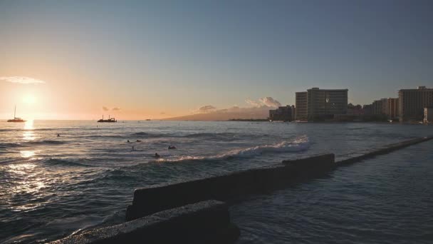 热带日落的迷人色彩。航行船只在海洋地平线上漂浮的轮廓。冲浪者乘风破浪。瓦胡岛，夏威夷的暑假慢动作. — 图库视频影像