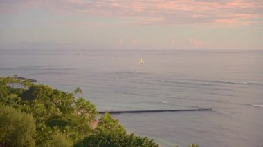 Tropikal günbatımının inanılmaz renkleri. Okyanus ufkunda yüzen yelkenli siluetleri. Oahu Adası, Hawaii Yaz Tatili.