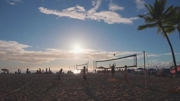 Honolulu, Hawaii, USA - 17. März 2021: Touristen spielen Basketball am berühmten Waikiki Beach in Honolulu. Schöner Sonnenuntergang auf der Insel Oahu vor blauem Himmel. DCI 4k — Stockvideo