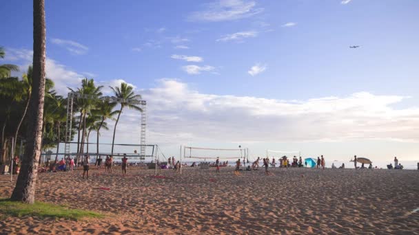 Honolulu, Hawaii, USA - 17. März 2021: Touristen spielen Basketball am berühmten Waikiki Beach in Honolulu. Schöner Sonnenuntergang auf der Insel Oahu vor blauem Himmel. Zeitlupe DCI 4k. — Stockvideo