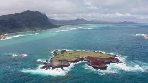 Volando drone sobre el océano. Vista de Rabbit Island. Las olas del Océano Pacífico bañan la arena amarilla de la playa tropical. Magníficas montañas de la isla hawaiana de Oahu. — Vídeos de Stock