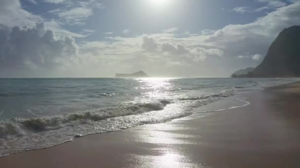 Barevný Aerial Pohled na tropickou pláž s tyrkysově modrou oceánskou vodou a vlnami lačícími na skryté bílé písečné pláži. Modrá obloha se zelenými stromy. Waimanalo Beach, Oahu Hawaii Island. 4k. — Stock video