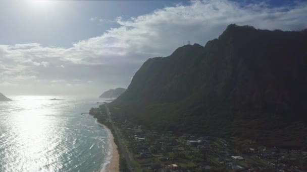 Färgglada antenn utsikt över steniga berg. En tropisk strand med turkosblått havsvatten och vågor som klappar på en dold vit sandstrand. Stranden Waimanalo, ön Oahu, Hawaii. — Stockvideo