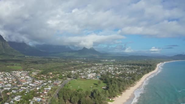 Colorata vista aerea delle montagne rocciose. Una spiaggia tropicale con acque turchesi blu oceano e onde che lambiscono su una spiaggia di sabbia bianca nascosta. Waimanalo Beach, Isola di Oahu, Hawaii. — Video Stock
