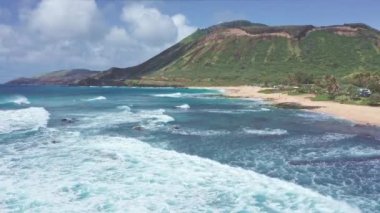 Oahu Hawaii tropik adasının kayalık kıyıları üzerinde uçuş. Sandy Beach manzarası. Pasifik Okyanusu Sahil Hattı. Mavi gökyüzüne karşı beyaz bulutlar. Hawaii 'de güneşli bir gün.