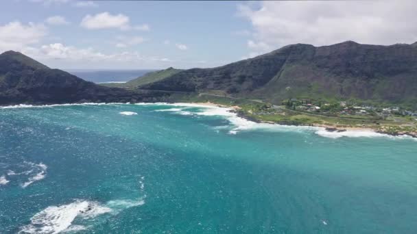 A Makapuu Beach Park felett repül. Óriási hullámok habzanak és fröcskölnek az óceánban. A Csendes-óceán vizének türkiz színe a trópusi szigeten. Csodálatos hegyei Hawaii szigetének, Oahunak.. — Stock videók