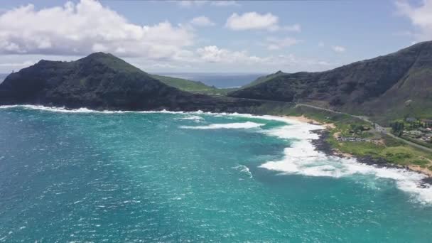 Volando sobre Makapuu Beach Park. Olas gigantes espumando y salpicando en el océano. El color turquesa del agua del Océano Pacífico en la isla tropical. Magníficas montañas de la isla hawaiana de Oahu. — Vídeo de stock