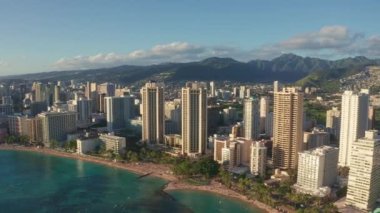Hawaii, Oahu 'da gün batımında Waikiki Sahili kuşbakışı çekim yaparken hava aracı yavaşça Honolulu siluetinin üzerinden uçuyor. Hawaii adası Oahu 'nun muhteşem dağları.