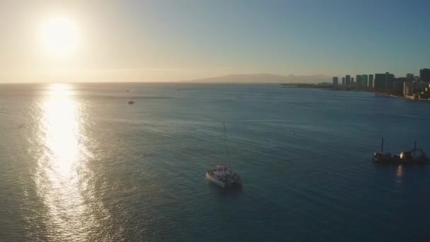 Avión aéreo panorámico volando lentamente sobre un colorido horizonte de Honolulu mientras se pone el sol en Oahu, Hawái con Waikiki Beach Shooting desde una vista de pájaro. Magníficas montañas de la isla hawaiana de Oahu. — Vídeo de stock