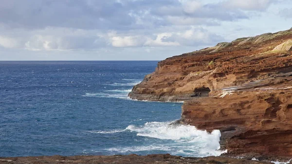 Blue Waves of the Pacific Ocean Beats Oahu Island Volcanic Cliffs (en inglés). Un día claro y soleado. Archipiélago Hawaii. ICD 4k —  Fotos de Stock