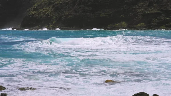 Blue Waves of the Pacific Ocean Beats Oahu Island Volcanic Cliffs. Turquoise water color. Clear sunny day. Archipelago Hawaii. DCI 4k — Zdjęcie stockowe