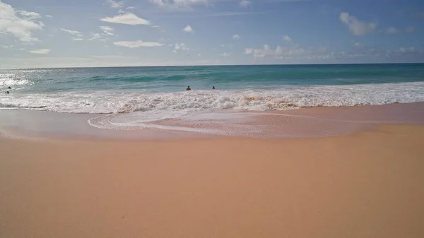 Az emberek úsznak az óceánban. Sárga homok Sandy Beachen, Oahu Hawaii trópusi szigetén. A Csendes-óceán vizének türkiz színe. Steadicam lövés. — Stock Fotó