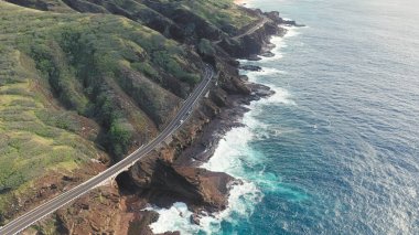 Oahu Hawaii tropik adasının kayalık kıyıları üzerinde uçuş. Kalanianaole Otoyolu Güney Sahili Oahu Hawaii Pasifik Okyanusu Kıyısı. Mavi gökyüzüne karşı beyaz bulutlar. Hawaii 'de güneşli bir gün.