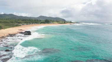 Oahu Hawaii tropik adasının kayalık kıyıları üzerinde uçuş. Sandy Beach manzarası. Pasifik Okyanusu Sahil Hattı. Mavi gökyüzüne karşı beyaz bulutlar. Hawaii 'de güneşli bir gün.