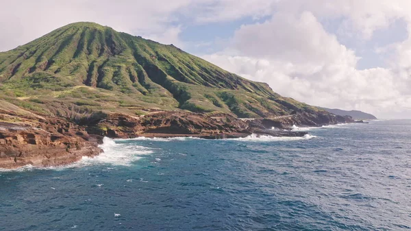 Flying over volcanic cliffs. Cinematic wild nature aerial 4K. Slow motion waves of transparent sea waters. Outdoor adventure travel to beautiful Hawaii beach. Untouched nature on sunny summer day. — Stock Photo, Image