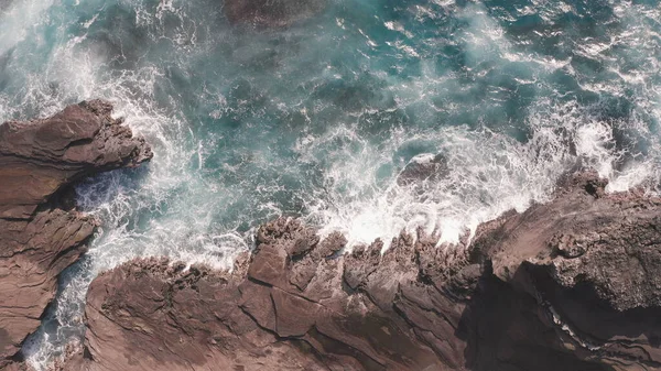 Luchtfoto van drone. Bovenaanzicht op de rotsachtige oceaan. Blue Waves of the Pacific Ocean stort neer op de rots. Wit zeeschuim. Vulkanisch strand van Tropisch eiland Oahu Hawaii. — Stockfoto