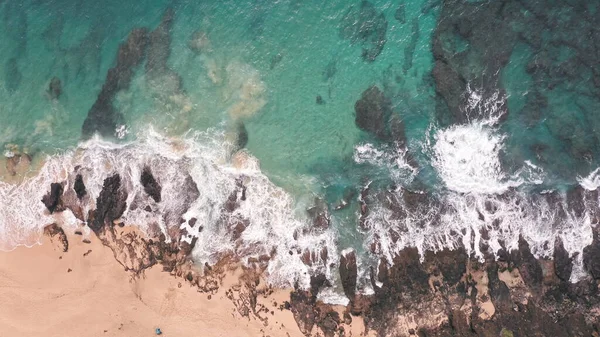 Повітряний постріл з дрона. Верхній вид на скелястий берег океану. Блакитні хвилі Тихого океану вдаряються об скелі. Біла морська піна. Вулканічний пляж на острові Оаху. — стокове фото