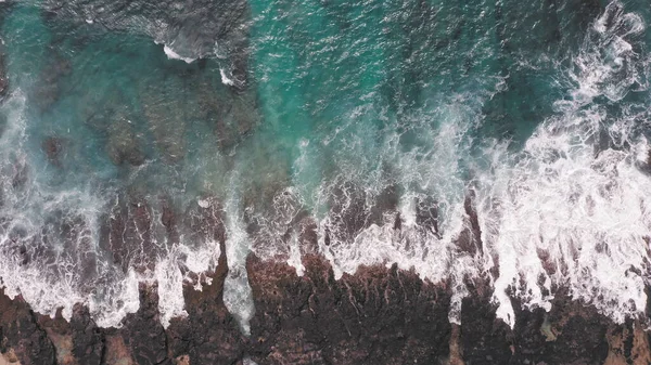 Tiro aéreo do drone. Vista superior na costa rochosa do oceano. As ondas azuis do Oceano Pacífico estão a cair na rocha. Espuma marinha branca. Praia vulcânica da Ilha Tropical Oahu Hawaii. — Fotografia de Stock