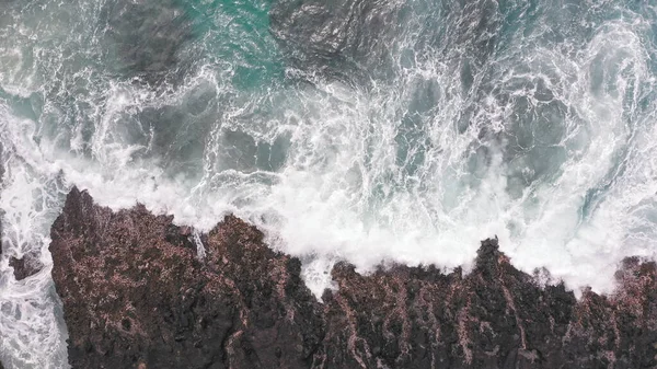 Aerial shot from drone. Top view on the rocky ocean shore. Blue Waves of the Pacific Ocean is crashing on the rock. White sea foam. Volcanic beach of Tropical Island Oahu Hawaii. — Stock Photo, Image