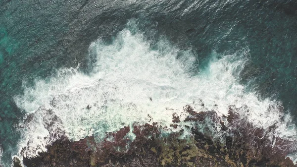 ドローンからの空中撮影。岩だらけの海の海岸の上からの眺め。太平洋の青い波は、岩の上で砕けていっています。白い海の泡。熱帯島の火山ビーチ｜オアフ島ハワイ. — ストック写真