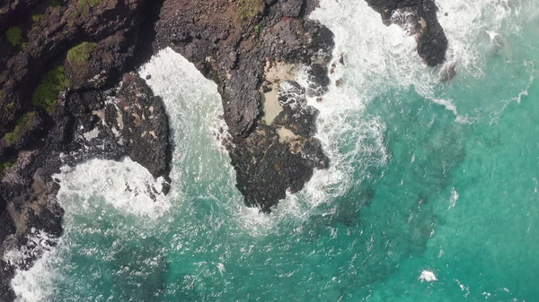 Strzał z powietrza z drona. Widok na skalisty brzeg oceanu. Kamera obraca się o 360. Błękitne Fale Oceanu Spokojnego rozbijają się na skale. Biała piana morska. Wulkaniczna plaża Tropikalnej Wyspy Oahu Hawaje. — Zdjęcie stockowe