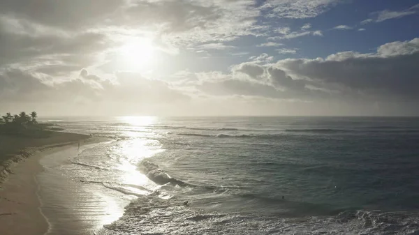 Zdjęcia lotnicze na wyspie Oahu na Hawajach. Dron lata po piaszczystej plaży. Widok na skaliste góry. Wczesnym rankiem na tropikalnej wyspie. Fale Oceanu Spokojnego myją brzeg. — Zdjęcie stockowe