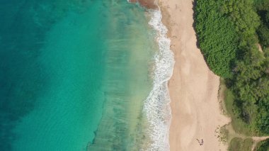 Yukarıdan aşağıya doğru hava görüntüsü. Beyaz kumlu güzel tropik sahil denizi. Üst Manzara. Hawaii Adası 'nda yaz mevsiminde boş ve temiz bir sahil..