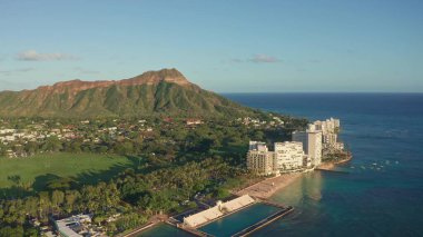 Waikiki Sahili ve Diamond Head Krateri 'nin gün batımında insansız hava aracı görüntüsü. Honolulu, Oahu, Hawaii, ABD' de ünlü bir turizm merkezi. Waikiki Sahili, arka planda Honolulu silueti.