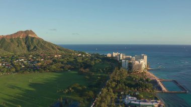 Waikiki Sahili ve Diamond Head Krateri 'nin gün batımında insansız hava aracı görüntüsü. Honolulu, Oahu, Hawaii, ABD' de ünlü bir turizm merkezi. Waikiki Sahili, arka planda Honolulu silueti.