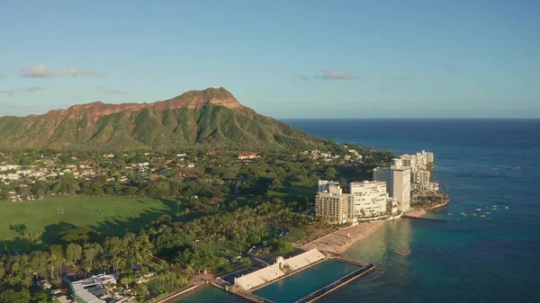 Waikiki Sahili ve Diamond Head Krateri 'nin gün batımında insansız hava aracı görüntüsü. Honolulu, Oahu, Hawaii, ABD' de ünlü bir turizm merkezi. Waikiki Sahili, arka planda Honolulu silueti.