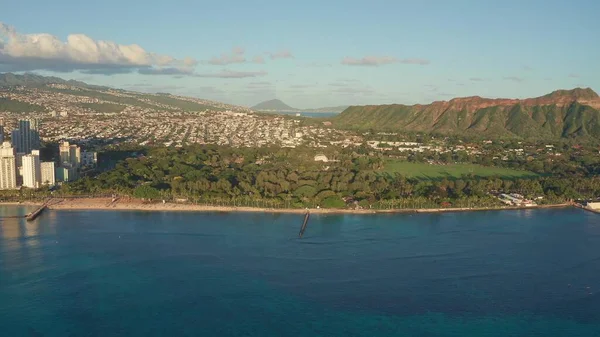 Waikiki Sahili ve Diamond Head Krateri 'nin gün batımında insansız hava aracı görüntüsü. Honolulu, Oahu, Hawaii, ABD' de ünlü bir turizm merkezi. Waikiki Sahili, arka planda Honolulu silueti.