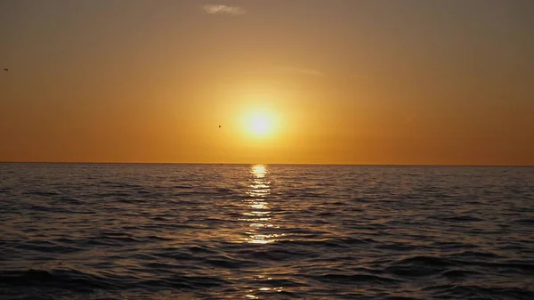 戏剧性的海洋日落。燃烧的天空和闪耀的金色波浪。日落海4k 。红色的天空，黄色的太阳和迷人的大海。夏日日落海景.慢动作. — 图库照片