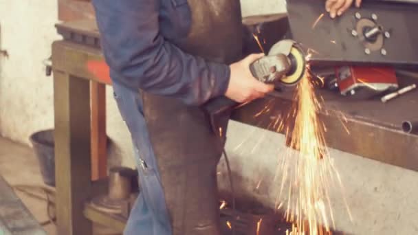 Handheld shot of Metal worker grinding in factory — Stock Video