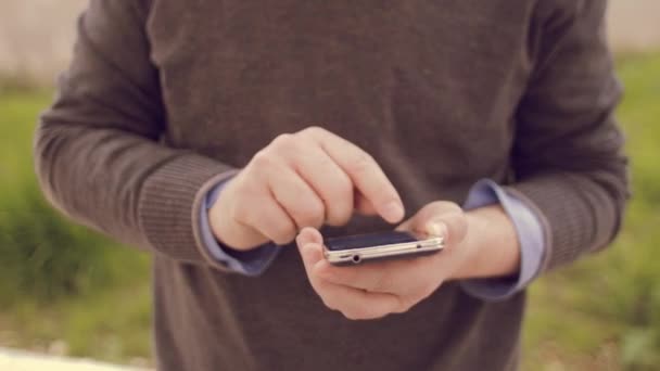 Hombre usando el teléfono inteligente mientras carga su coche eléctrico — Vídeos de Stock