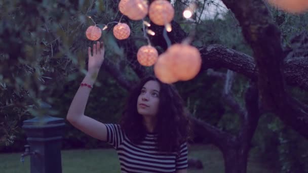 Joven mujer jugando con linterna en el jardín — Vídeos de Stock