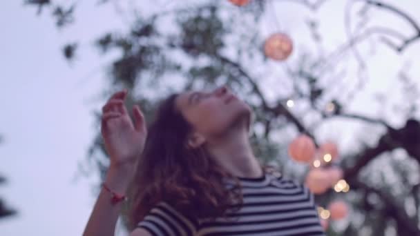 Slow-motion shot van jonge vrouw spelen met lantaarn in de tuin — Stockvideo
