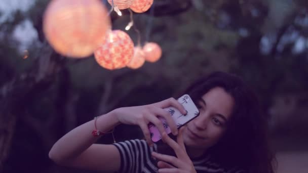 Jonge vrouw selfie te nemen onder lantaarns — Stockvideo