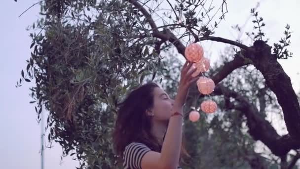 Cámara lenta de la joven mujer jugando con la linterna en el jardín — Vídeos de Stock