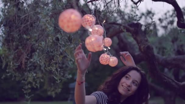 Повільний знімок молодої жінки, що грає з ліхтарем в саду — стокове відео