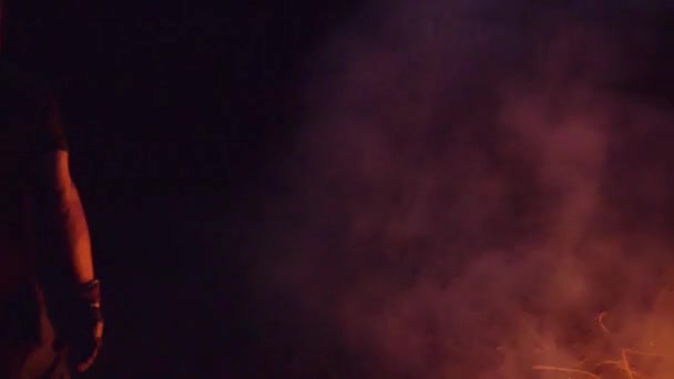Медленный кадр человека, горящего сухими ветвями на костре — стоковое видео