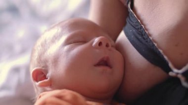 Yeni doğan erkek bebek uykuda annenin göğsünde