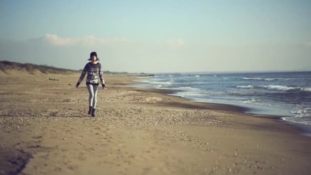 Дівчина-підліток, що йде на пляжі — стокове відео