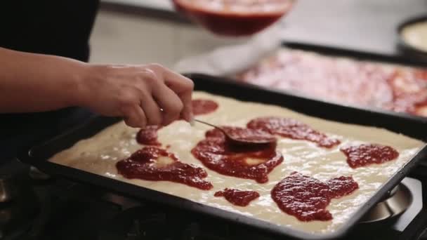 Vrouw applaying saus op pizza — Stockvideo