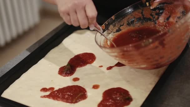 Женщина накладывает соус на пиццу — стоковое видео
