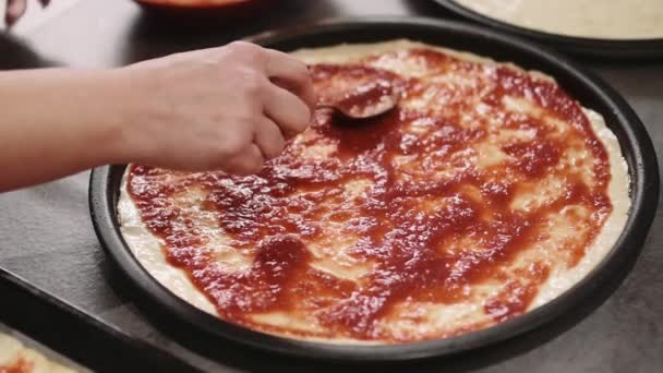 Woman applaying  sauce on pizza — Stock Video