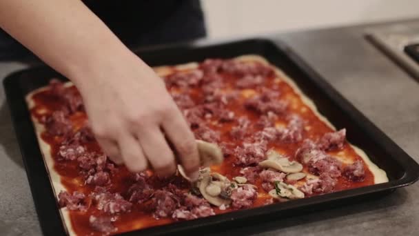 Женщина накладывает грибы на пиццу — стоковое видео